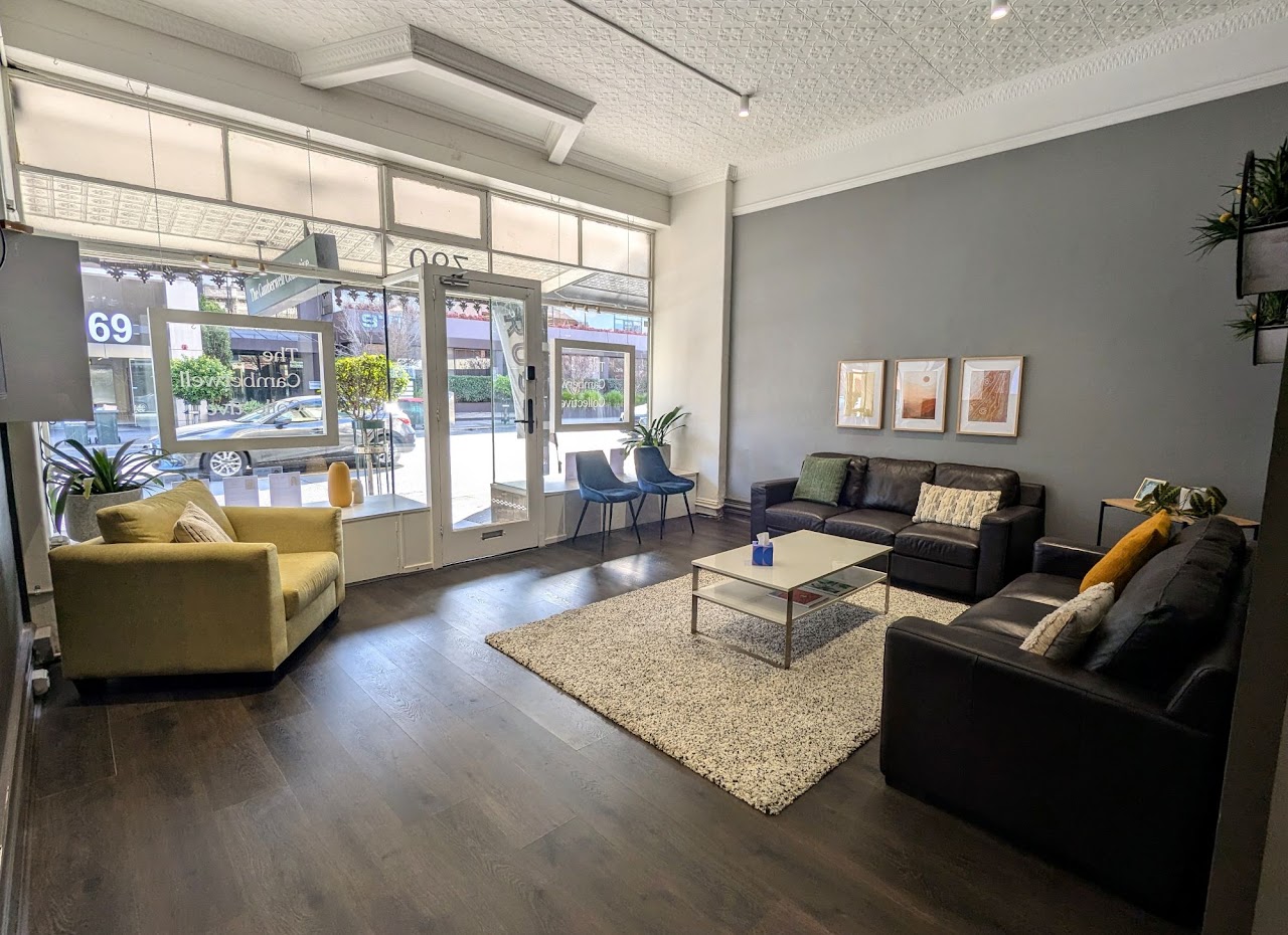 The street-facing waiting area at The Camberwell Collective, with large windows, sofas and an armchair